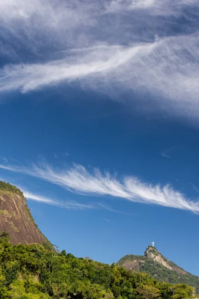 Beautiful view to Christ the Redeemer Statue on mountain top with blue sky and white clouds, Rio de Janeiro, Brazil
