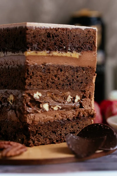 Ein Stück Schokoladenkuchen Mit Karamell Und Blumen Auf Dem Hintergrund — Stockfoto