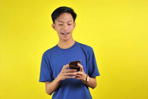 Sarı Arka Planda Izole Edilmiş Akıllı Telefon Kullanarak Gülümseyen Yakışıklı — Stok fotoğraf