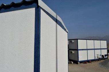 Mavi gökyüzü olan modern bir binanın dikey görüntüsü.