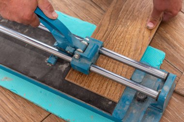 Adam fayans kesme makinesi kullanarak fayansları kesiyor..