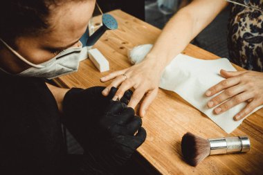 Virüs COVID için maske ve koruyucu ekranla çalışan bir güzellik uzmanı.