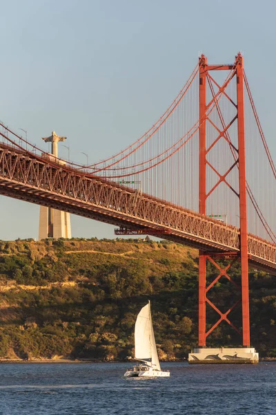 ポルトガル リスボン中心部の日没時にテジョ川とクリスト レイ像の上に25 Abril Bridgeへの美しい景色 — ストック写真