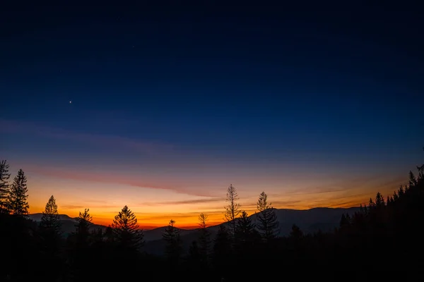 Sunset with stars in the sky and a gradual milky way view of Lysa Hora Czech Republic.