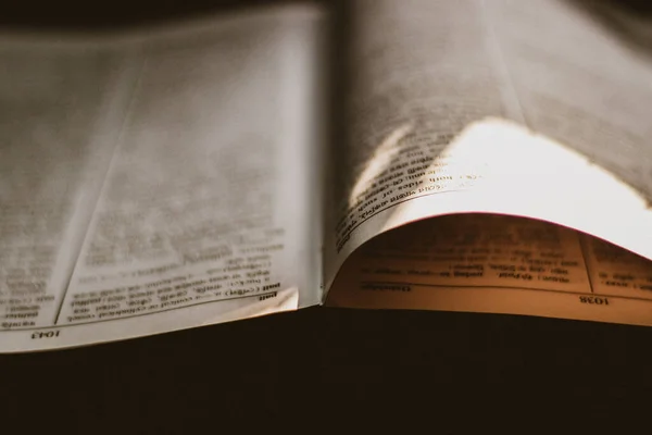 open book with a bible on background, close up