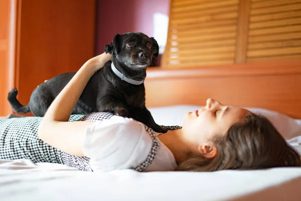 Yatakta Bir Kadının Üstünde Siyah Bir Köpek Köpek Yatak Konsepti — Stok fotoğraf