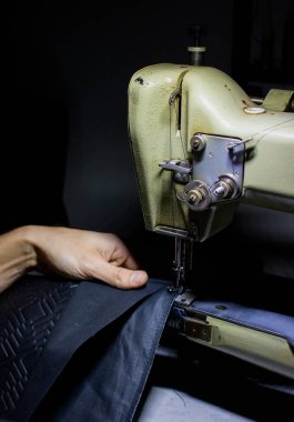 Deri ve dikiş makinesiyle çalışan bir zanaatkar.