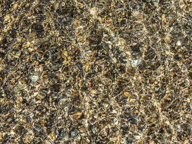 Rahatlamak için arka plan dokusu. Güneş ışığında bir su deposunun dibindeki taşlar. Doğanın şaşırtıcı yaratımları.