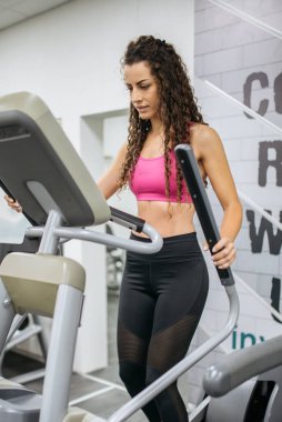 Muscular curly athlete doing cardio training 