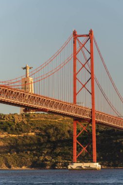 25 de Abril Köprüsü 'nün güzel manzarası Tejo Nehri ve Cristo Rei Heykeli üzerinde gün batımı saatinde, Lizbon, Portekiz şehir merkezi