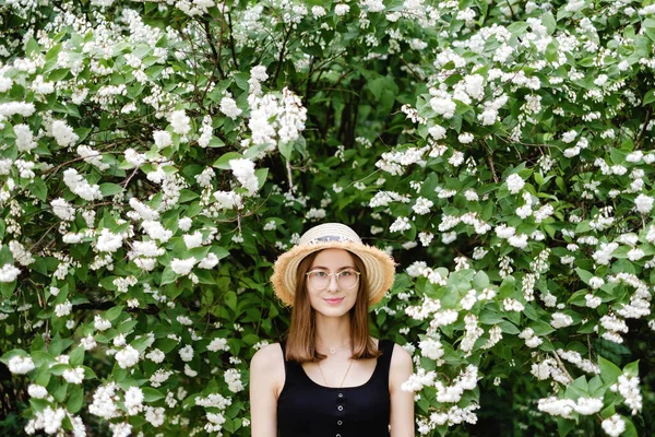Young Woman Summer Hat Eye Glasses Walks Flowering Trees — стоковое фото