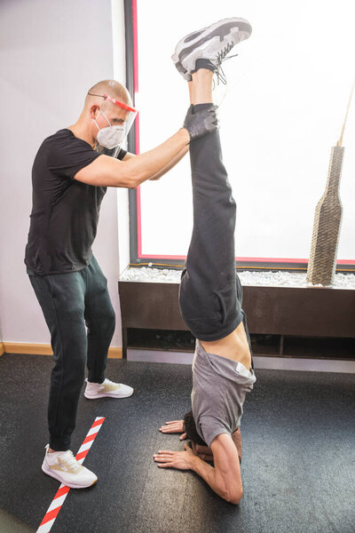 Young man doing personal training with instructor