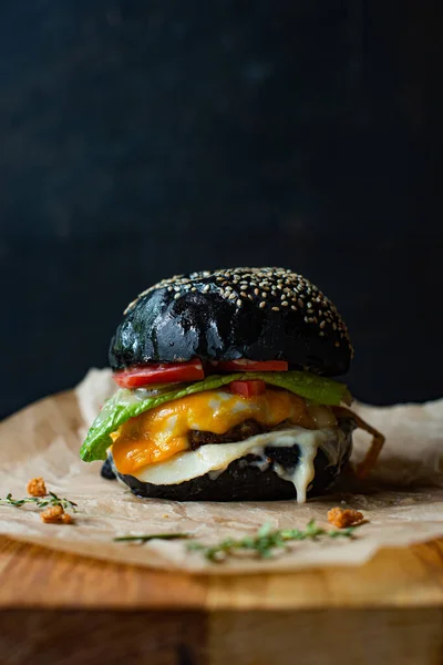 Hamburguesa Negra Sobre Tablero Madera Sobre Fondo Negro —  Fotos de Stock