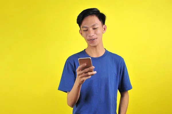 Glad Unge Kjekke Asiatiske Menn Smiler Med Smarttelefon Isolert Gul – stockfoto