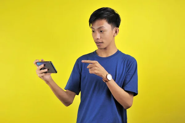 Chockad Ansikte Asiatisk Man Vit Skjorta Tittar Telefonskärmen Gul Bakgrund — Stockfoto