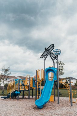Çocuk bulutlu bir yaz gününde oyun sahasında oturuyor..