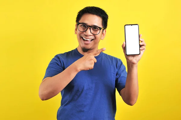 Gelukkig Aziatische Man Tonen Een Telefoon Scherm Wijzend Geïsoleerd Gele — Stockfoto