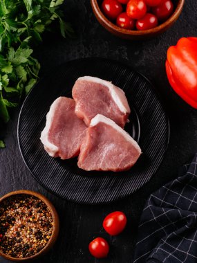 Siyah tabakta taze domuz filetosu.