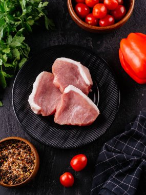 Siyah tabakta taze domuz filetosu.