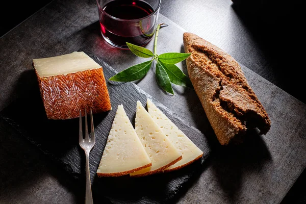 Вкусные Ломтики Сыра Manchego Вылечить Шифер Красное Вино Хлеб — стоковое фото