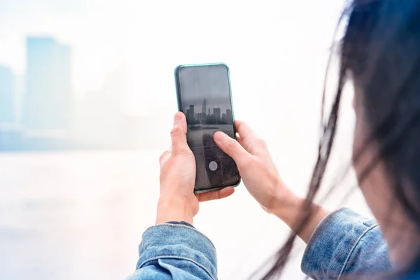 城市景观在智能手机上 通过上海的屏幕观看中国妇女屏幕 — 图库照片