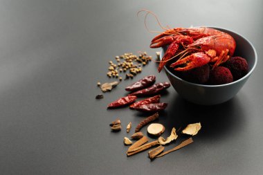 Kerevit kırmızısı, siyah arka planda kızarması için otlu bebek ıstakozu.