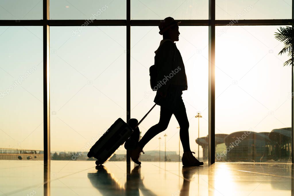 walking traveler with suitcase, passenger for tour in the airport terminal for air traveling