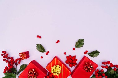 Noel süsü. Mor arka planda kırmızı hediye kutusu. Noel, kış, yeni yıl konsepti. Düz konum, üst görünüm, kopyalama alanı
