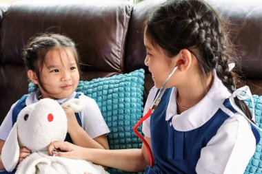 iki küçük kız gülümseyerek ve Doktor stetoskop ile oynayan. Çocuk ve sağlık kavramı.