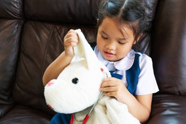 küçük kız gülümseyerek ve Doktor stetoskop ile oynayan. Çocuk ve sağlık kavramı.