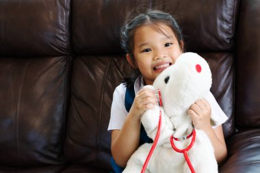 küçük kız gülümseyerek ve Doktor stetoskop ile oynayan. Çocuk ve sağlık kavramı.