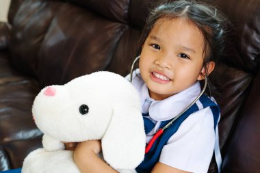 küçük kız gülümseyerek ve Doktor stetoskop ile oynayan. Çocuk ve sağlık kavramı.