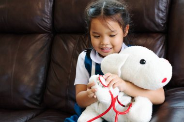 küçük kız gülümseyerek ve Doktor stetoskop ile oynayan. Çocuk ve sağlık kavramı.