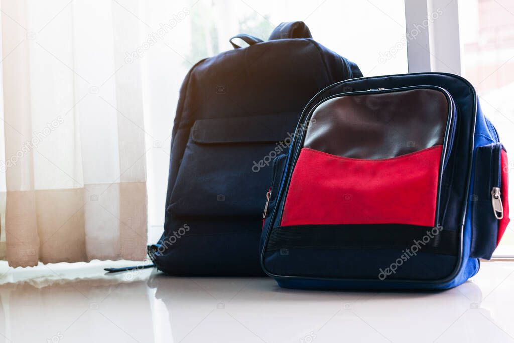 Back to school concept. Blue  backpack lean on the glass door for two kids