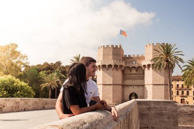Attractive young couple with Torres de Serranos gate on the background. Tourists in Valencia, Spain.