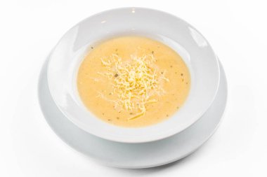 Beyaz arka planda beyaz tabakta peynir çorbası.