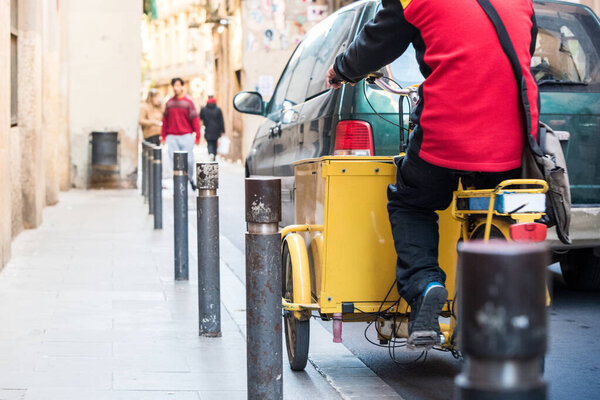 Courier on yellow cargo bicycle on city traffic.