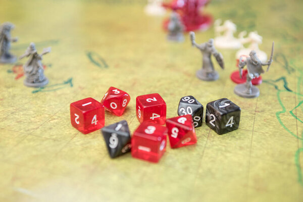 Set of dices and game miniatures on the green battlefield. Role play dungeons and dragons. Close up photography.