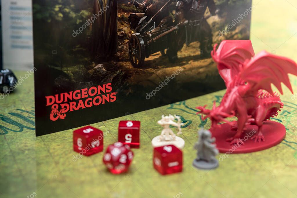 Barcelona, Spain, 22 December 2019: Playing Dungeons and Dragons role play board game. Dices and miniatures on the battlefield. Focus on the logo of the role play game.