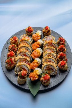 Hafif arka planda siyah bir tabakta Tempura suşi rulosu