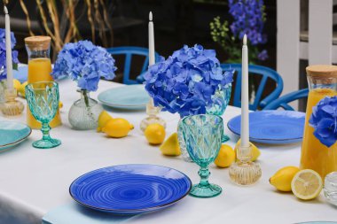 Mavi ve turkuaz aksanlı şık bir açık hava masası.