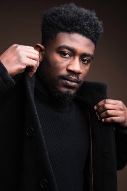 Close-up of African elegant man in black jacket looking at camera