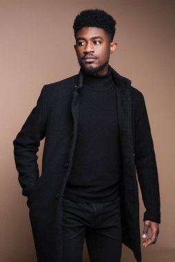 Close-up of African elegant man in black jacket posing at camera