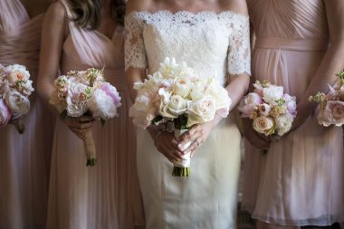 Bride and Bridesmaids Holding Pastel Rose Bouquets in Lace Dress