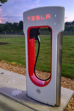 Close up of a Tesla EV charging tower in a parking lot.