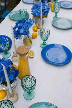 Mavi ve turkuaz aksanlı şık bir açık hava masası.