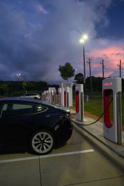 A car getting power at an EV charging location in a parking lot.