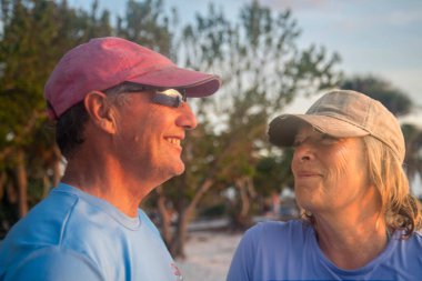 Active Seniors embrace Paddleboarding  at sunset