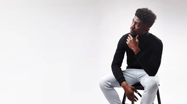 Portrait of man looking aside at free copy space, touching his chin