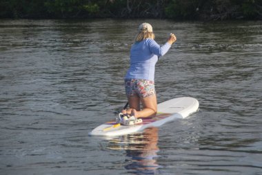 Active Seniors embrace Paddleboarding  at sunset